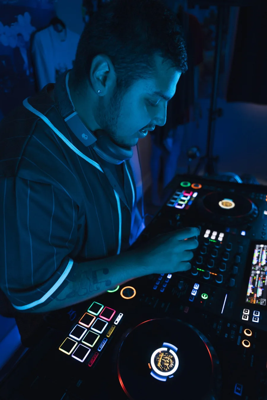 Dill the Menace mixing during a blue-lit DJ session